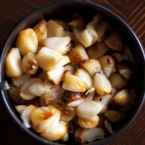 roasted garlic cloves in a black bowl
