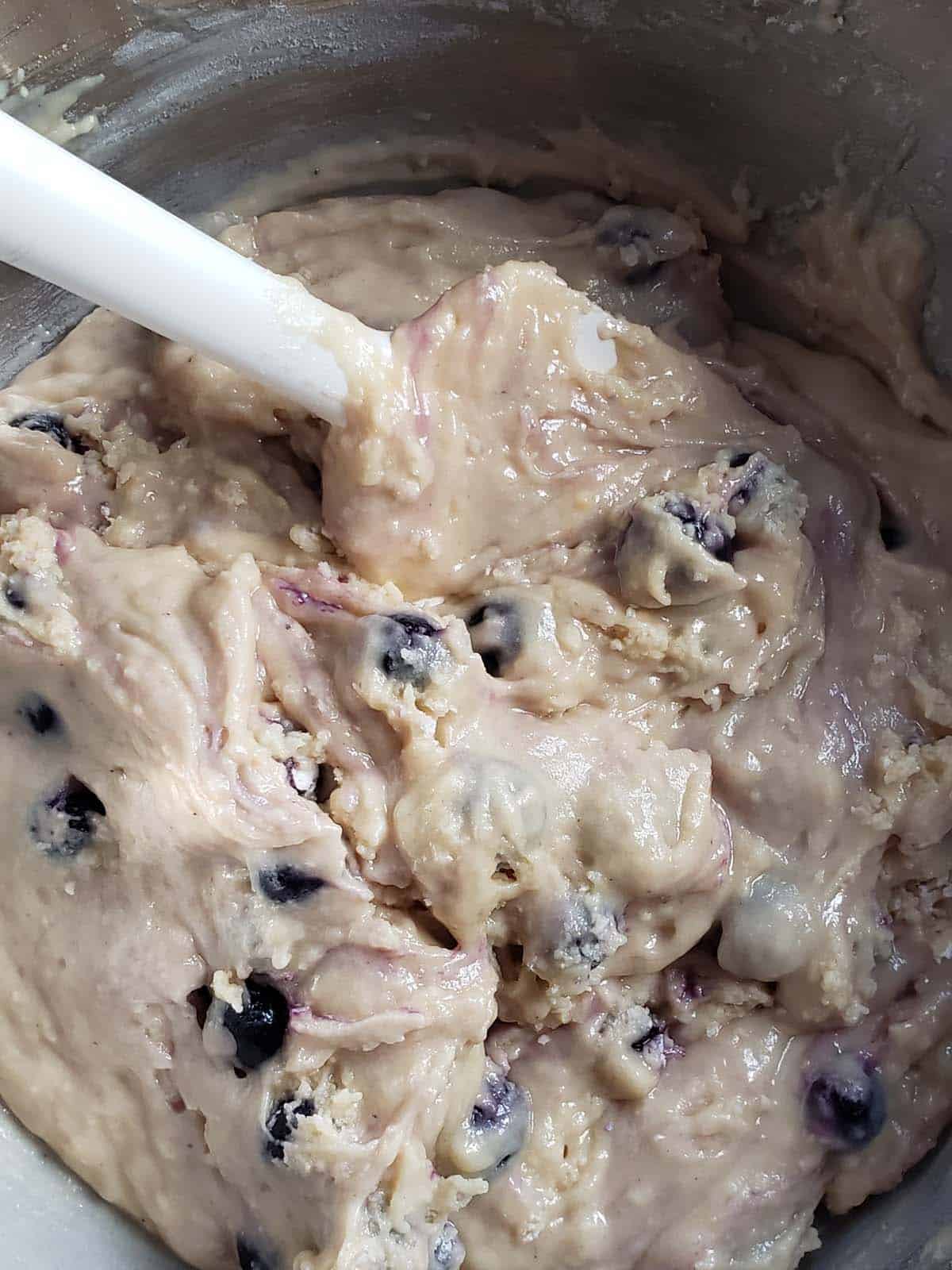 Blueberry muffin batter in a metal bowl.