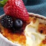 Close up of creme brulee topped with mixed berries.