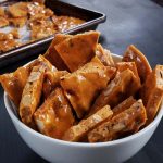 pieces of hazelnut brittle in a white bowl