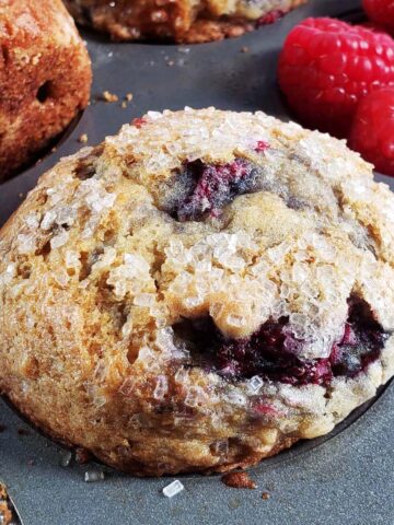 Close up of a raspberry apple muffin in a muffin tin.