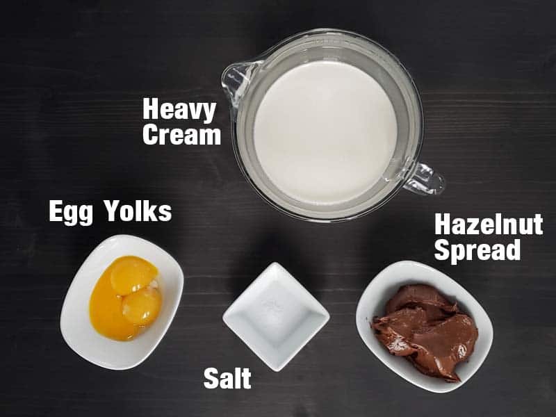 Hazelnut creme brulee ingredients on a dark background.
