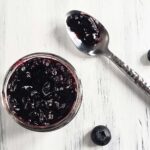 jar of blueberry jam on a white surface
