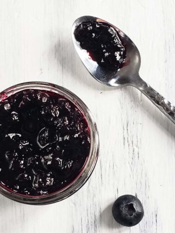 jar of blueberry jam on a white surface