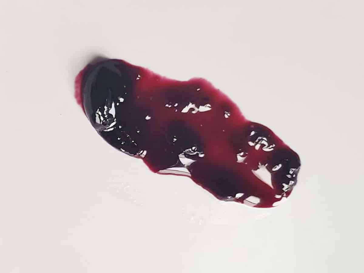 Blueberry jam sample brushed across a white plate.