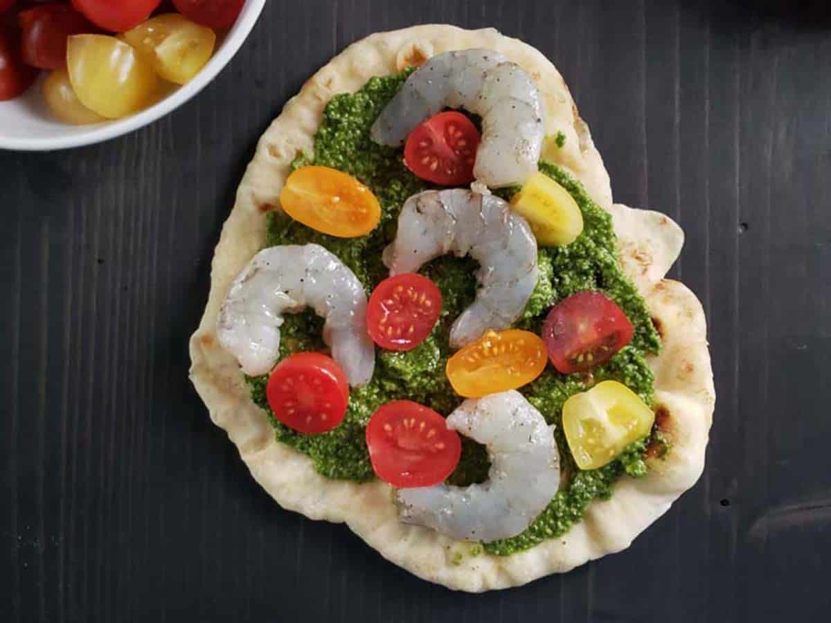 Flatbread topped with pesto, tomatoes, and shrimp.
