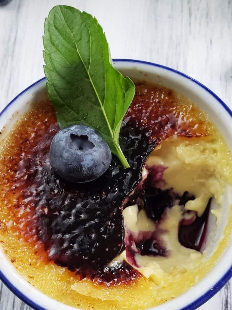 Blueberry creme brulee with a bite missing.