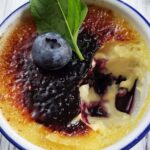 Close up of blueberry creme brulee with a bite taken out.