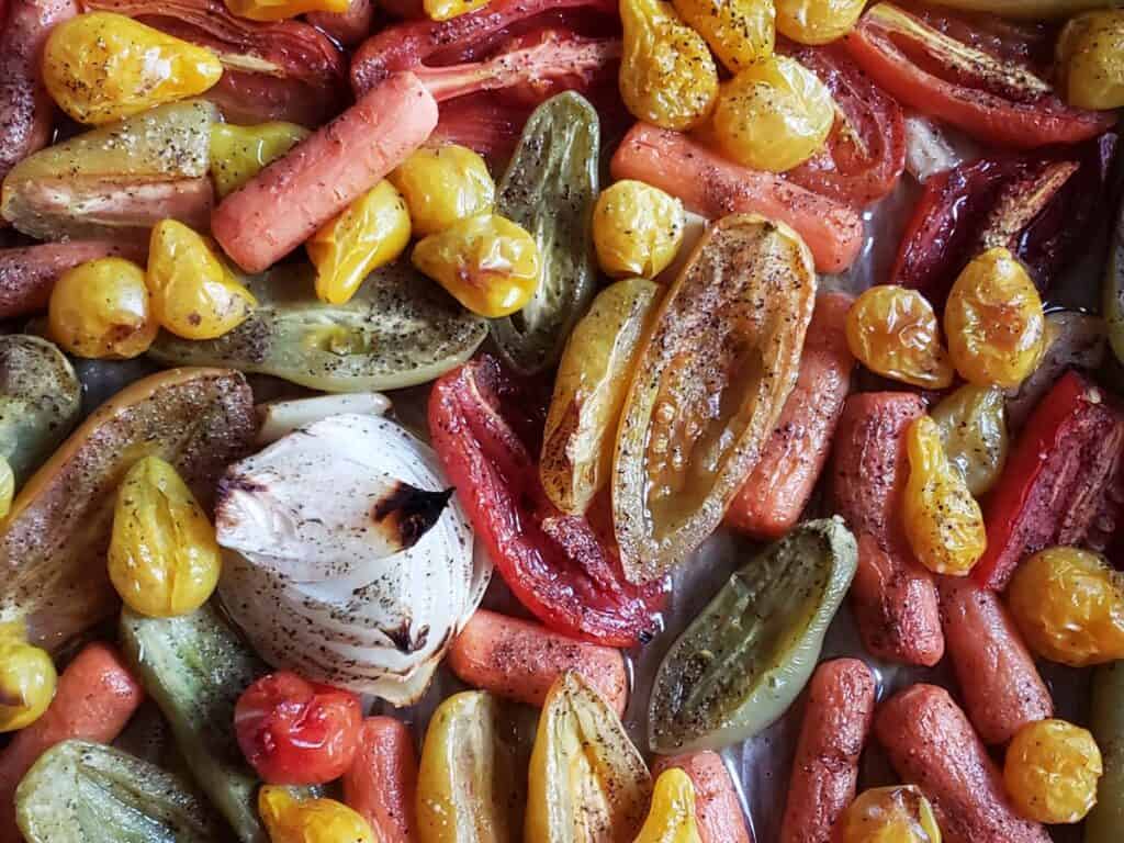 roasted tomatoes and carrots on a sheet pan