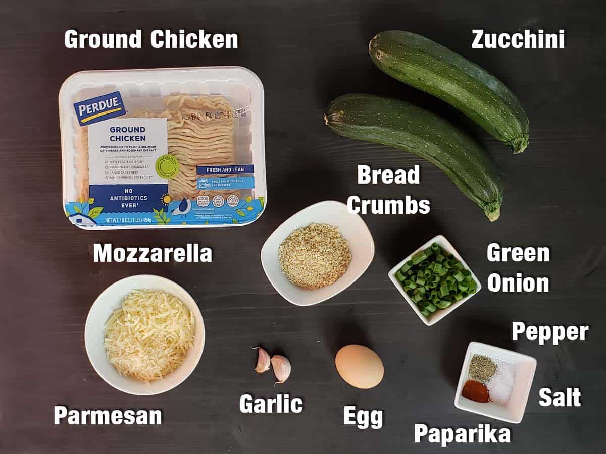 Chicken zucchini patty ingredients on a dark background.