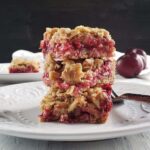 Stack of three plum bars on a white plate.