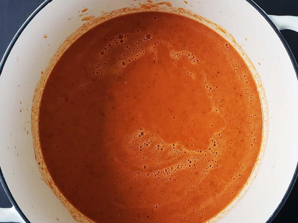 Pureed tomato soup in a white dutch oven.