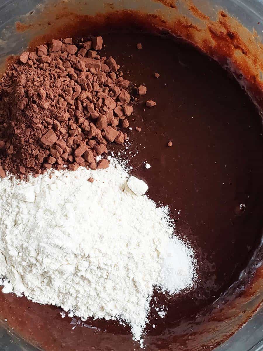 Brownie batter topped with flour and cocoa powder.