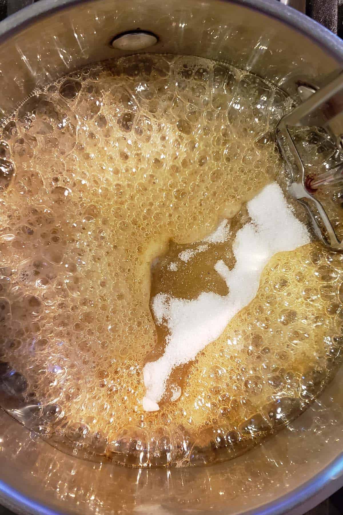 Boiling sugar and honey in a saucepan partially dissolved sugar.