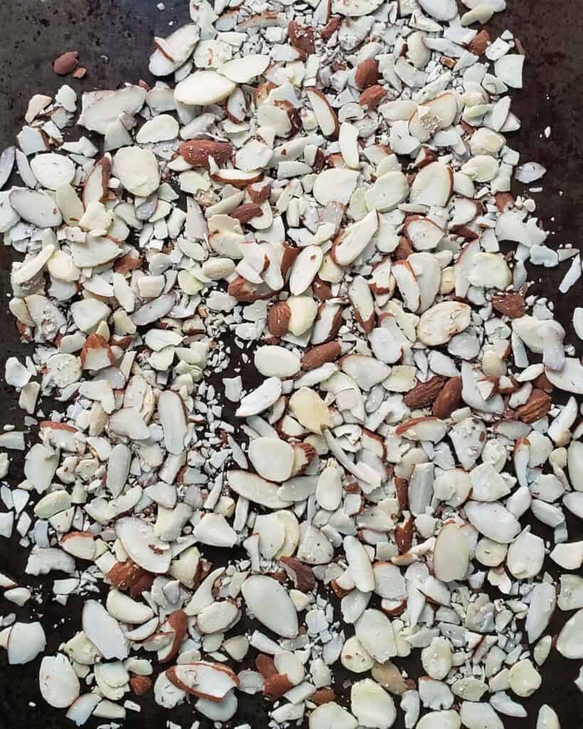 untoasted almonds on a baking sheet