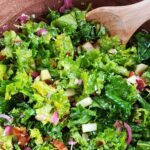Kale apple salad in a wooden bowl.