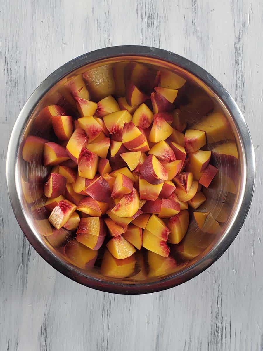 Diced peaches in a metal bowl.