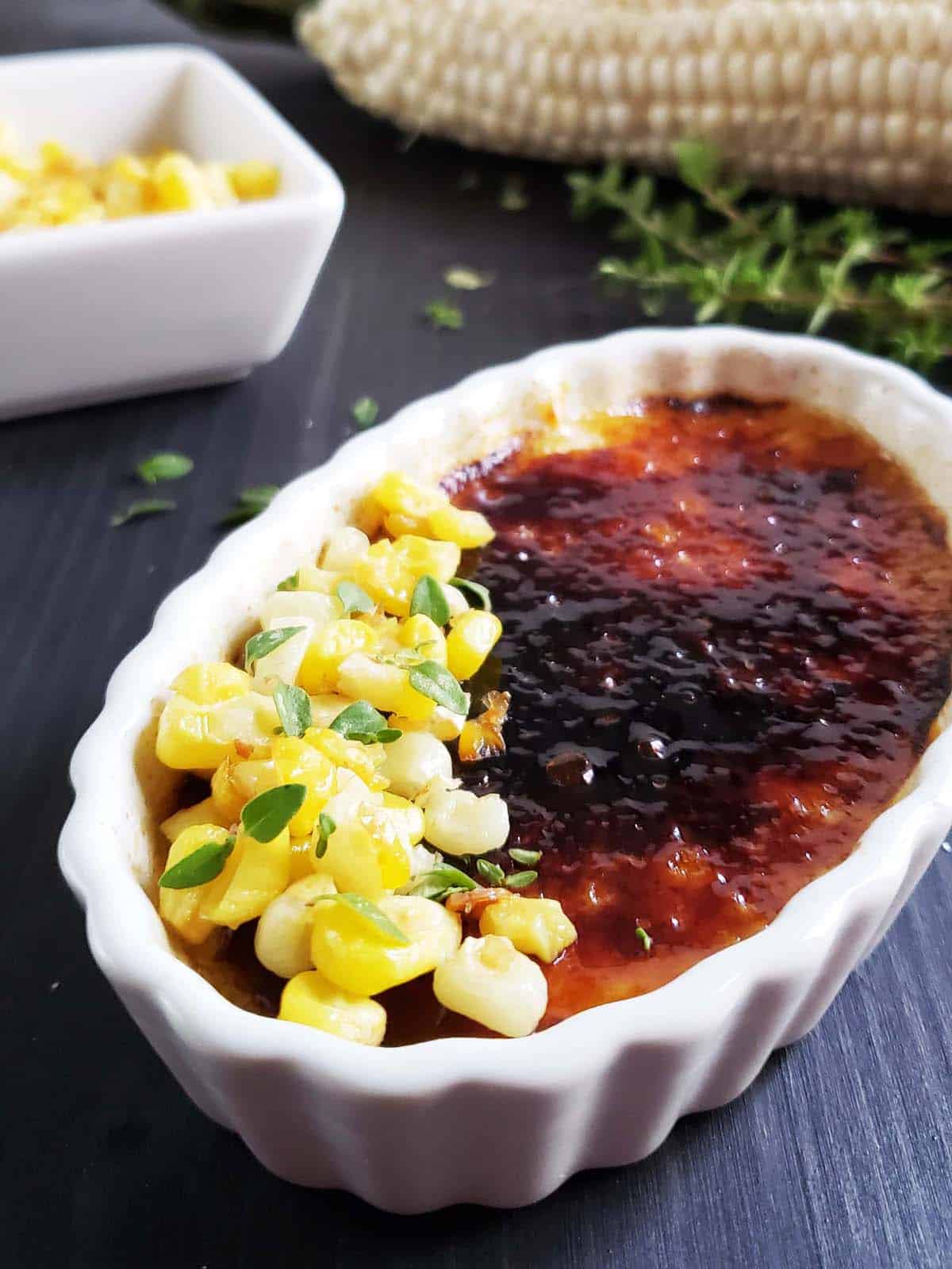 Close up of sweet corn creme brulee topped with burnt sugar and corn kernels.