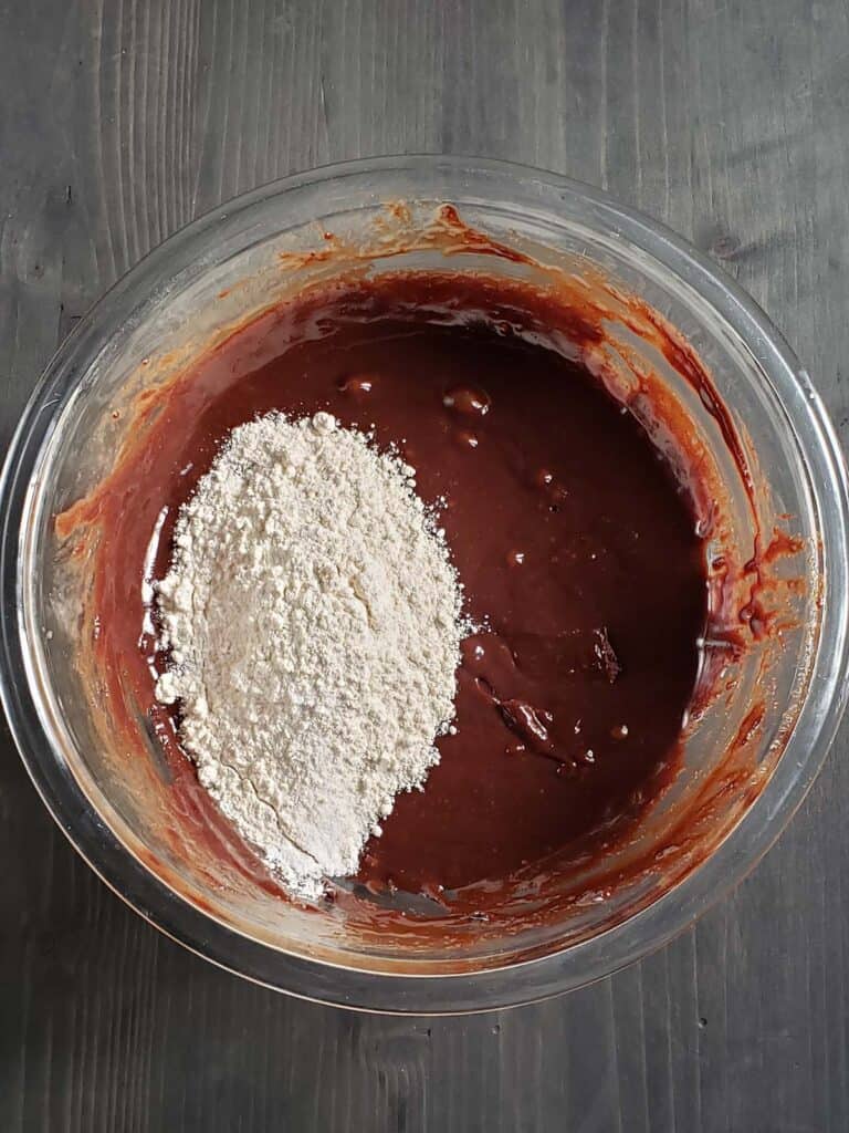 Brownie batter in a glass bowl with flour.