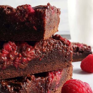 three raspberry nutella brownies stacked on top of each other