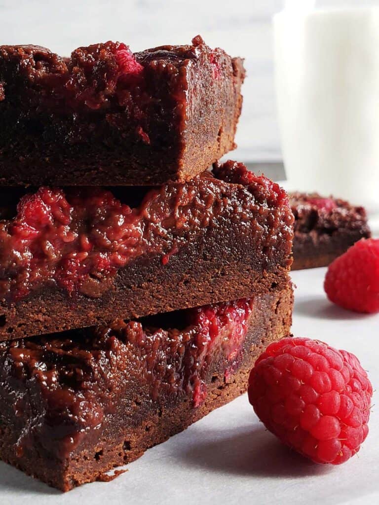 Three raspberry nutella brownies stacked on top of each other.
