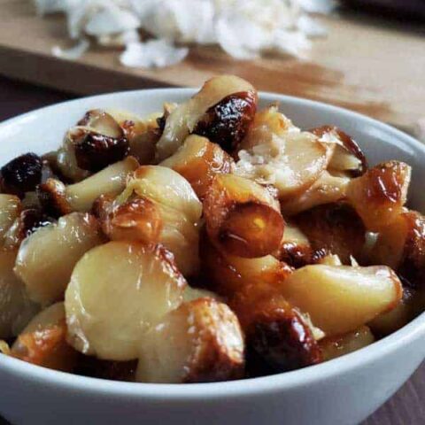 Roasted cloves of garlic in a white bowl.