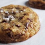 close up of a chocolate chip cookie sprinkled with flakey salt