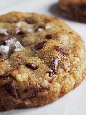 close up of a chocolate chip cookie sprinkled with flakey salt