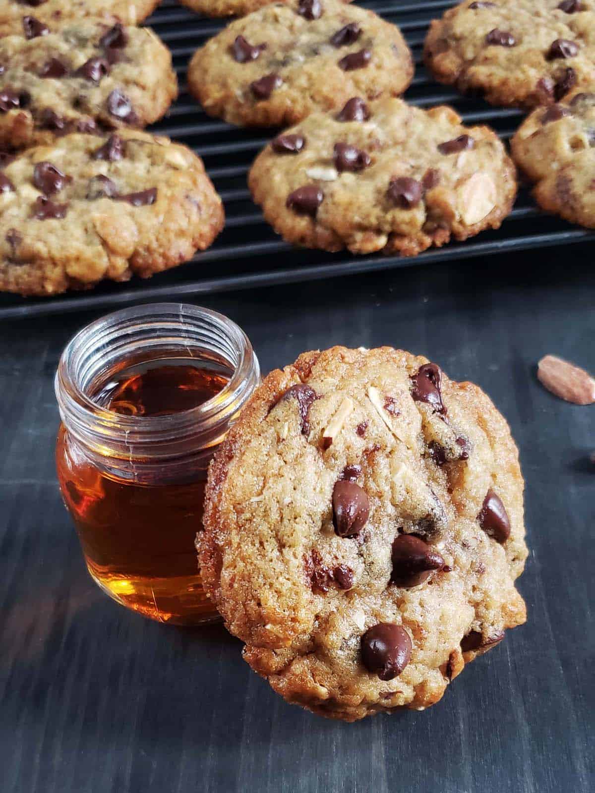 Amaretto chocolate chip cookie leaning against a glass shot glass filled with amaretto.