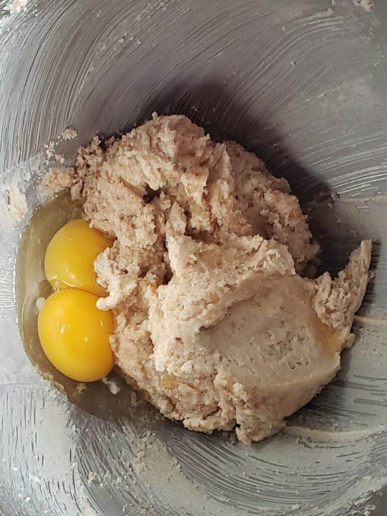 Cookie dough and egg yolks in a metal bowl.