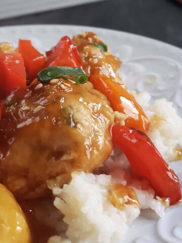 Chicken pineapple meatballs and peppers on a bed of white rice.