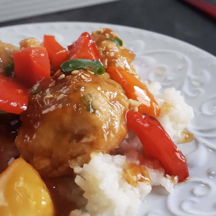 Chicken pineapple meatballs and peppers on a bed of white rice.