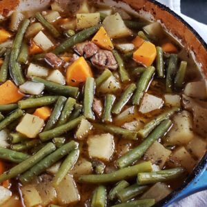 Pork stew in a blue dutch oven.