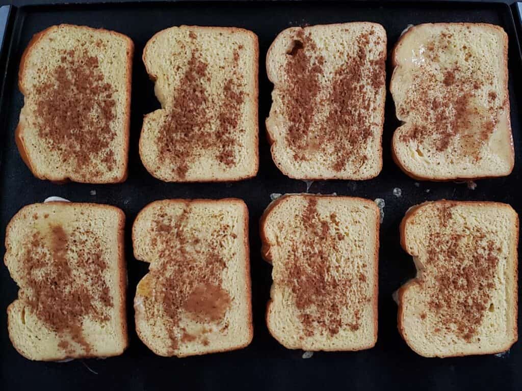 8 slices of french toast cooking on a griddle
