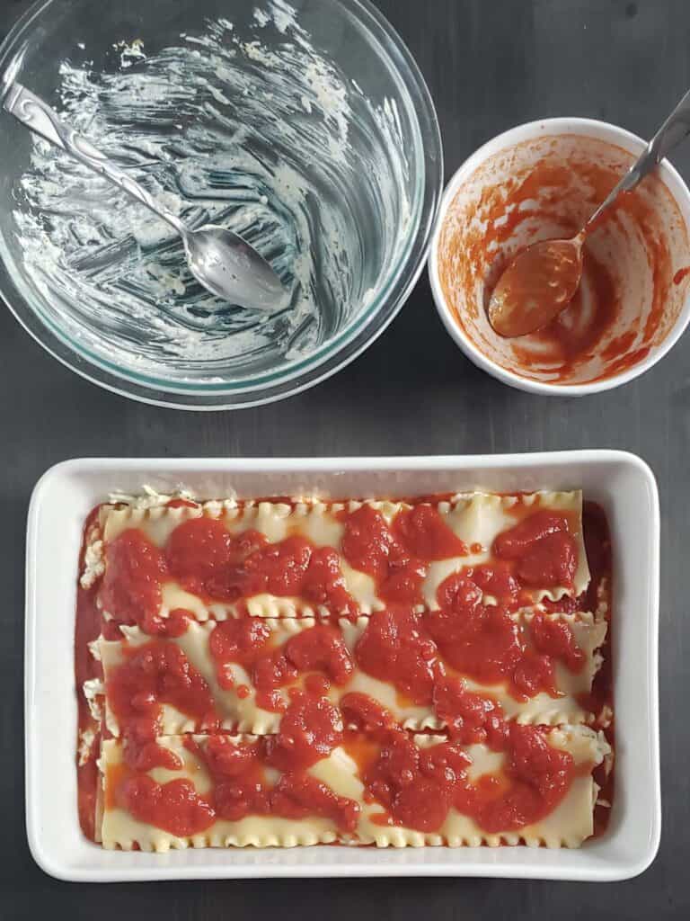 layered lasagna in a white casserole dish