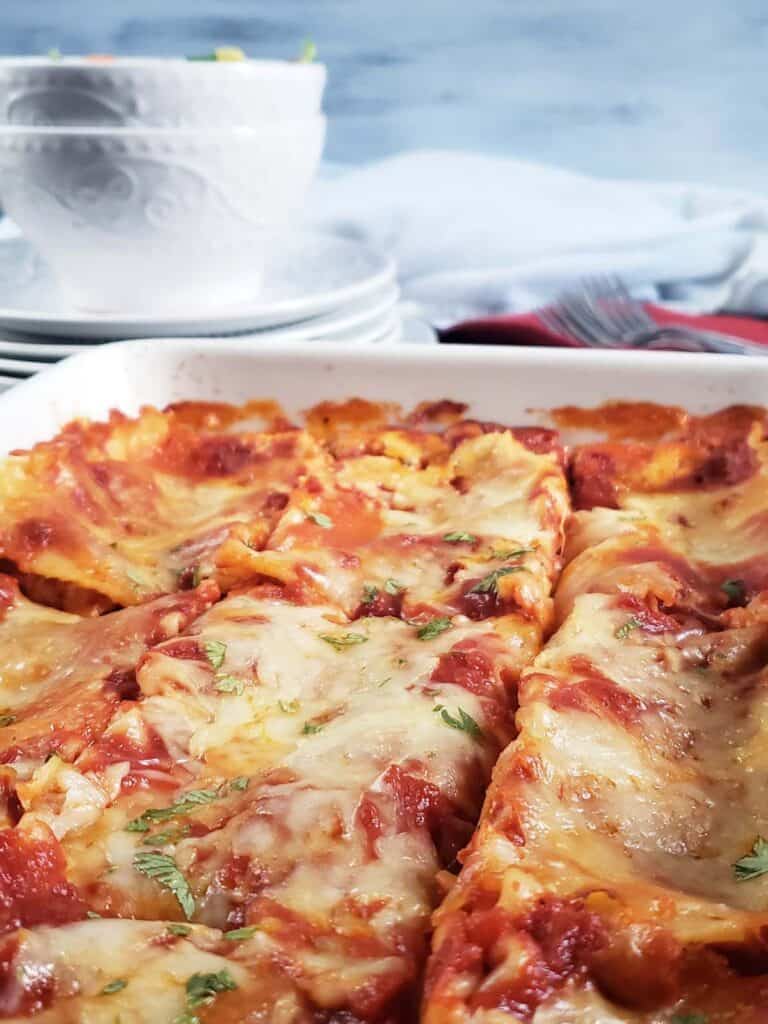 close up of cut lasagna in a white dish