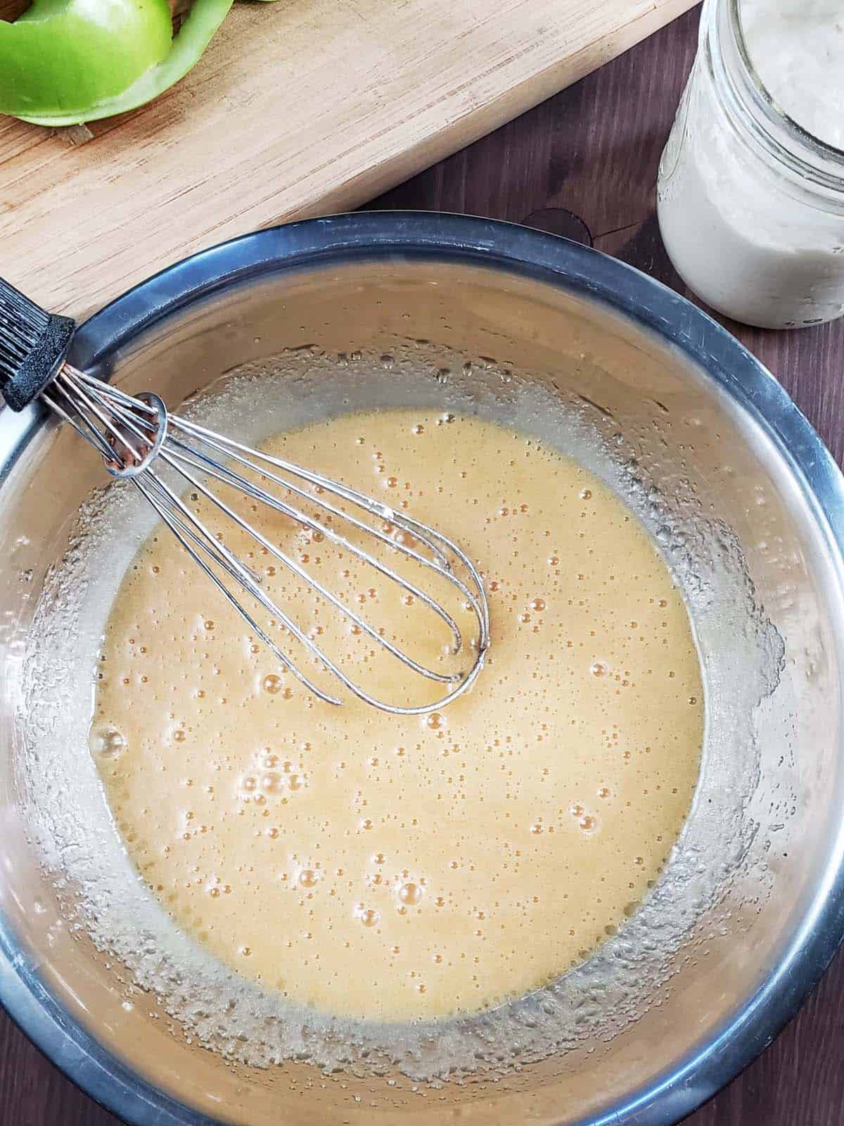 Wet ingredients whisked together in a metal bowl.