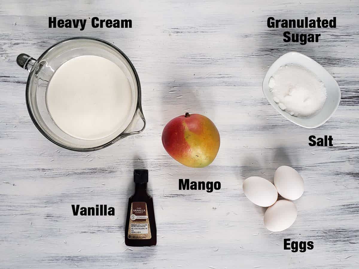 Mango creme brulee ingredients on a white surface.