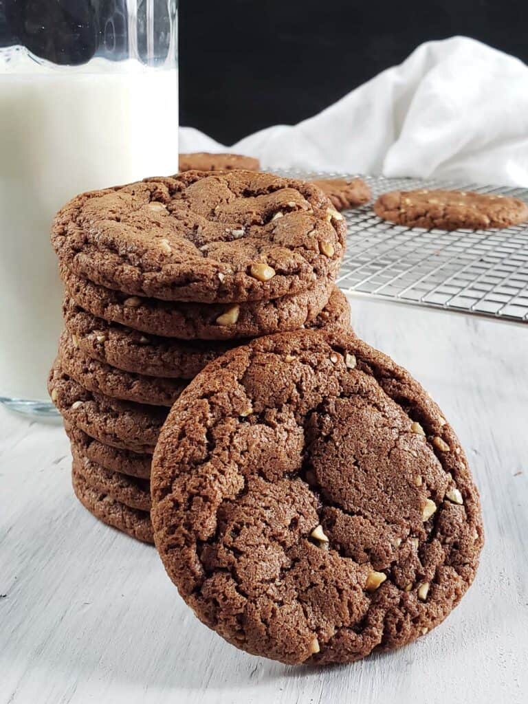 Stack of Nutella brownie cookies next to a glass of milk.
