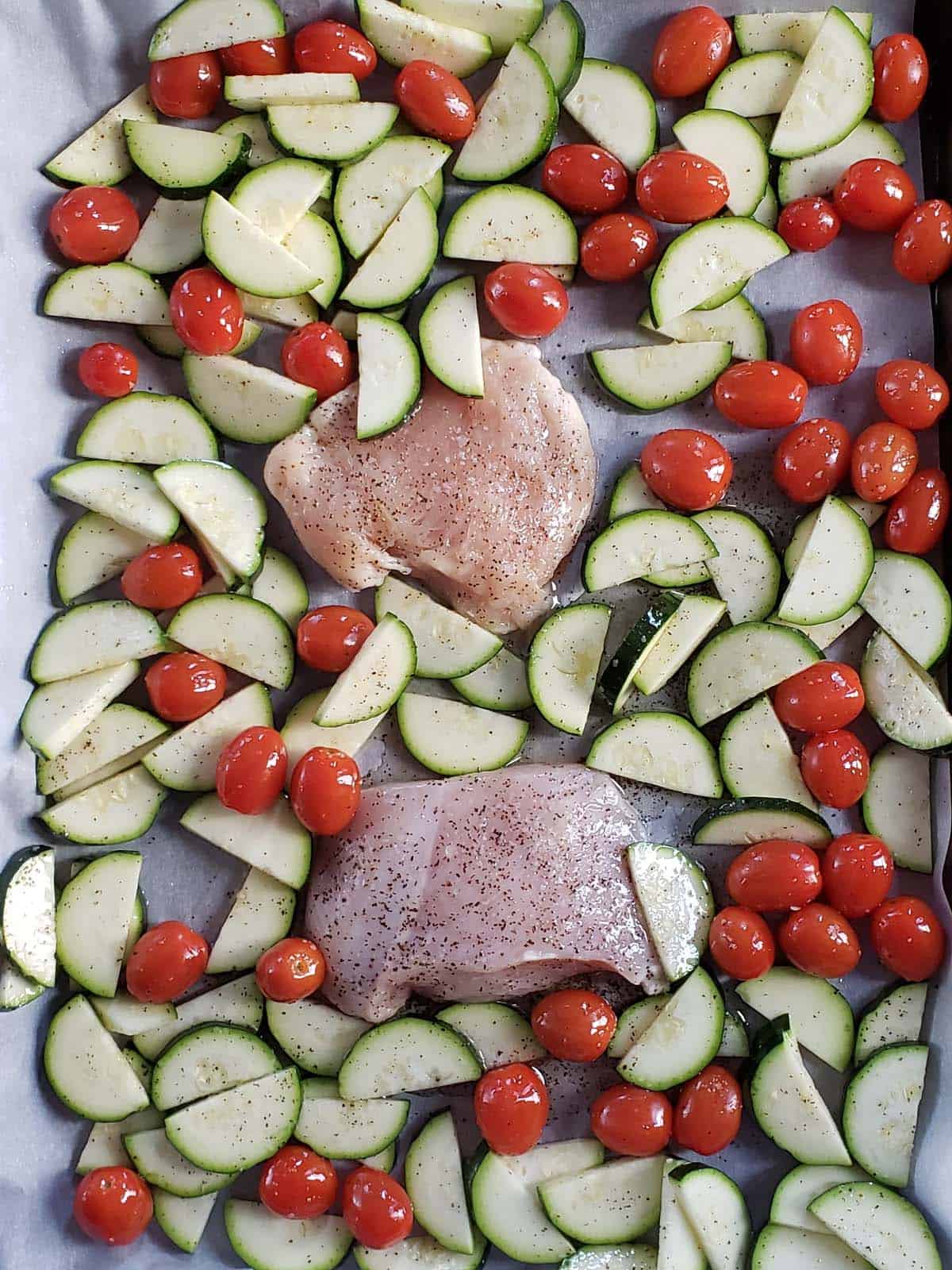 Zucchini, tomatoes, and chicken on a sheet pan,