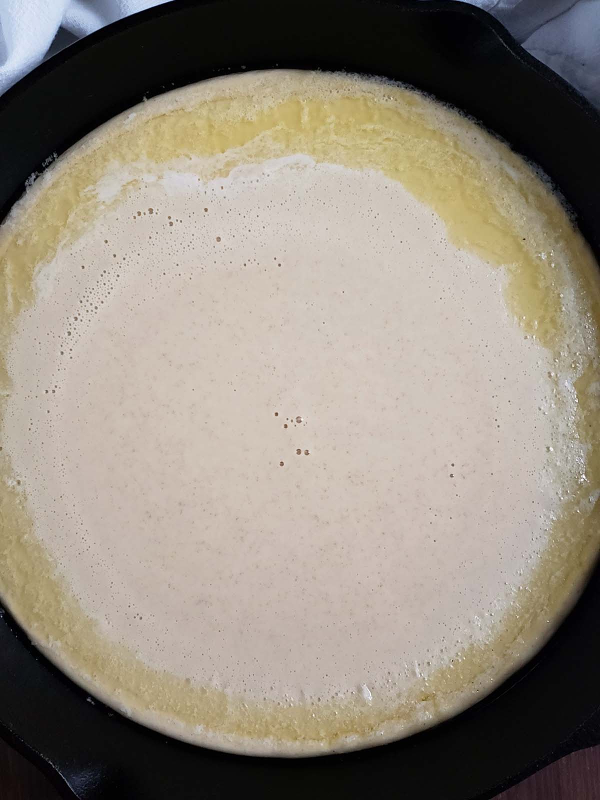 Dutch baby batter in a cast iron skillet.