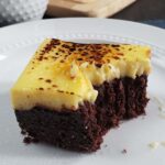 Creme brulee brownie with a bite missing on a white plate.