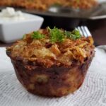 Close up of a twice baked potato cup on a white paper napkin.