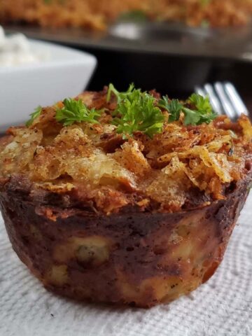 Close up of a twice baked potato cup on a white paper napkin.