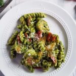 Shrimp pesto pasta on a white plate.