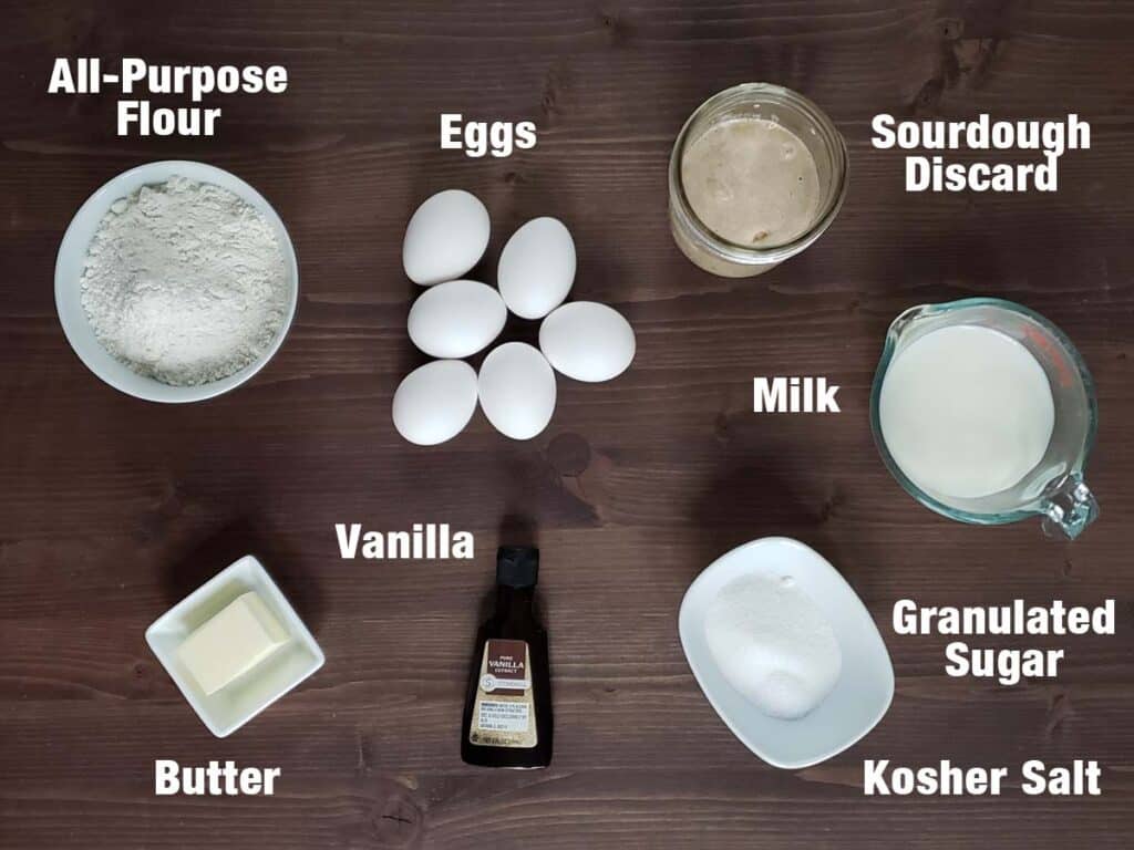 Sourdough dutch baby ingredients on a wood surface.