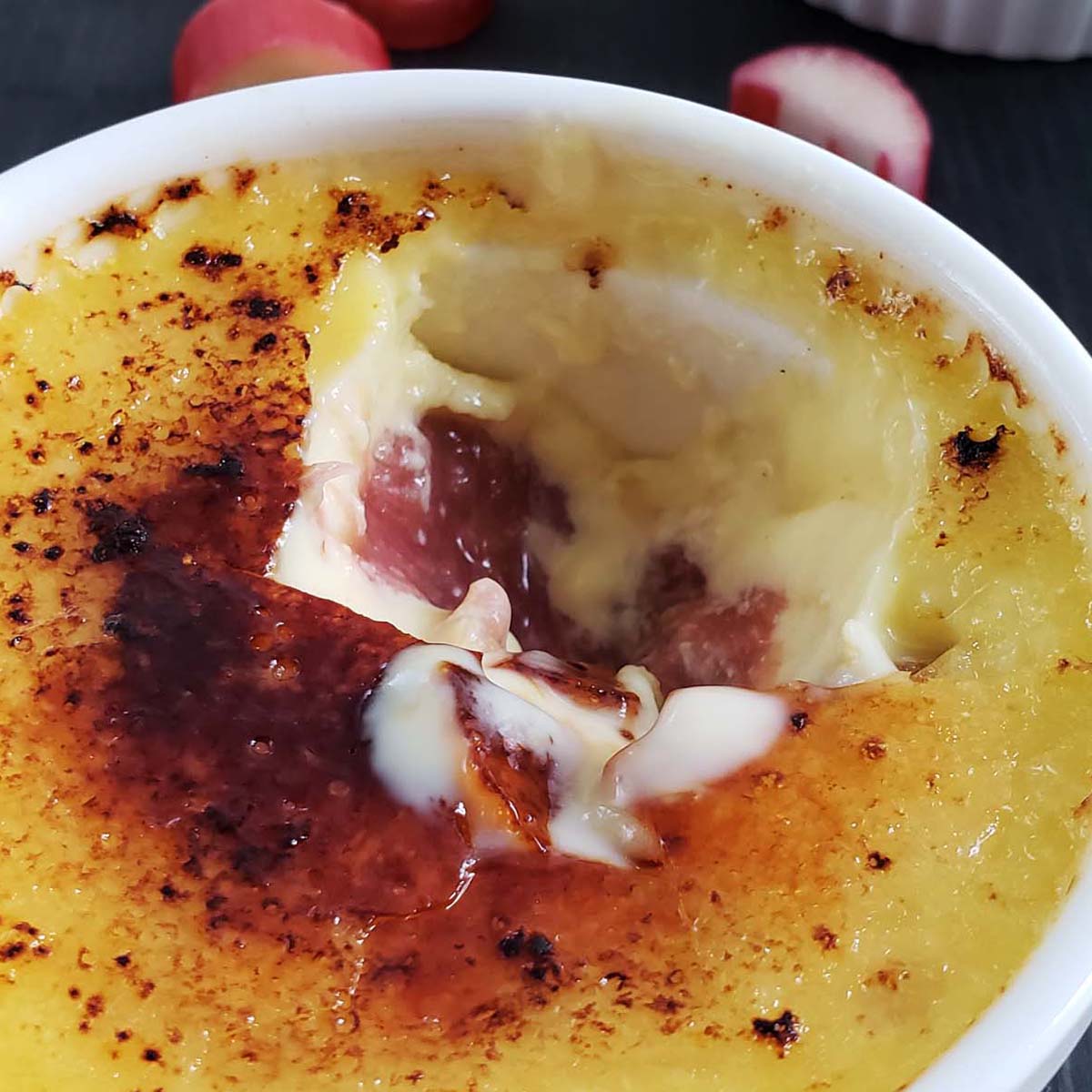 Close up of rhubarb creme brulee with a bite missing.