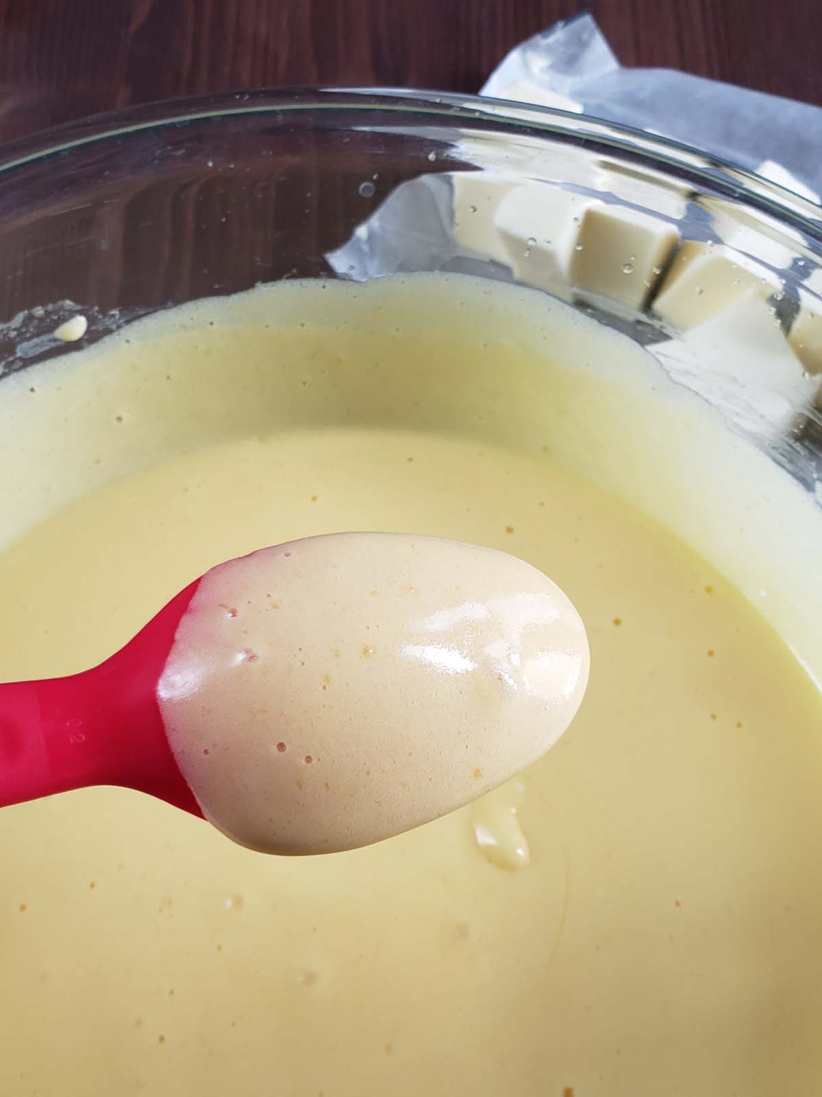 Lemon curd coating the back of a spoon.