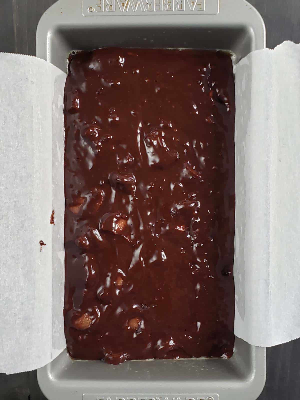 Chocolate rhubarb cake batter in a loaf pan.