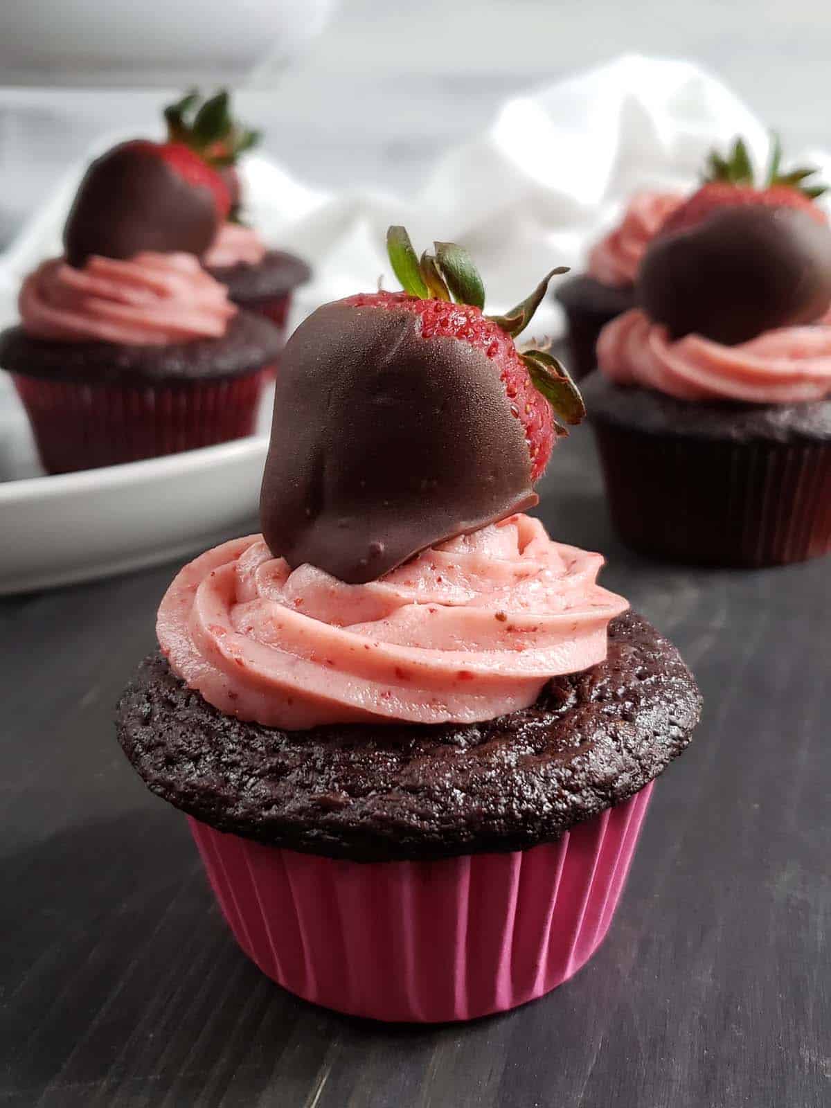Chocolate strawberry cupcake topped with a chocolate covered strawberry.